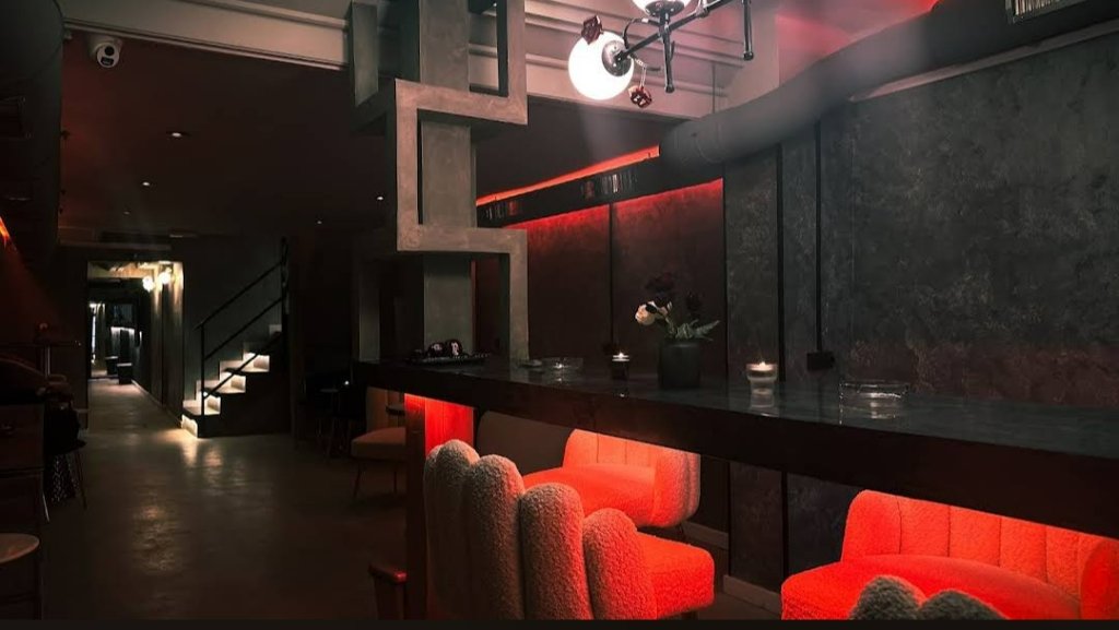Interior del club Rolling Stoned en Barcelona con barra, sillones rojos e iluminación ambiental
